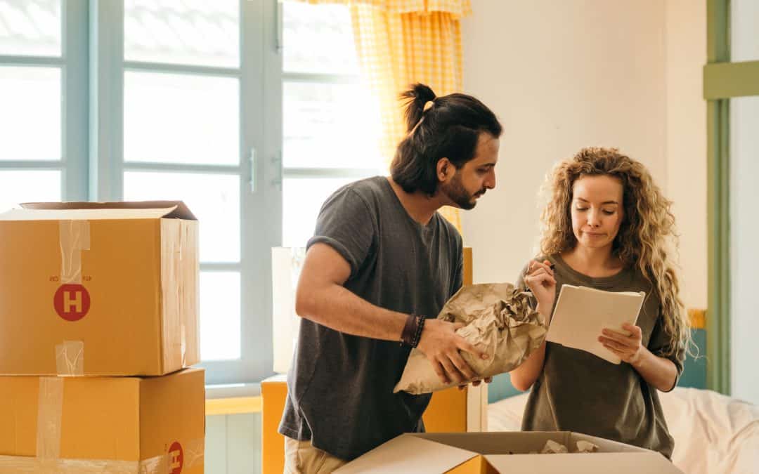 Happy couple unpacking boxes in new home