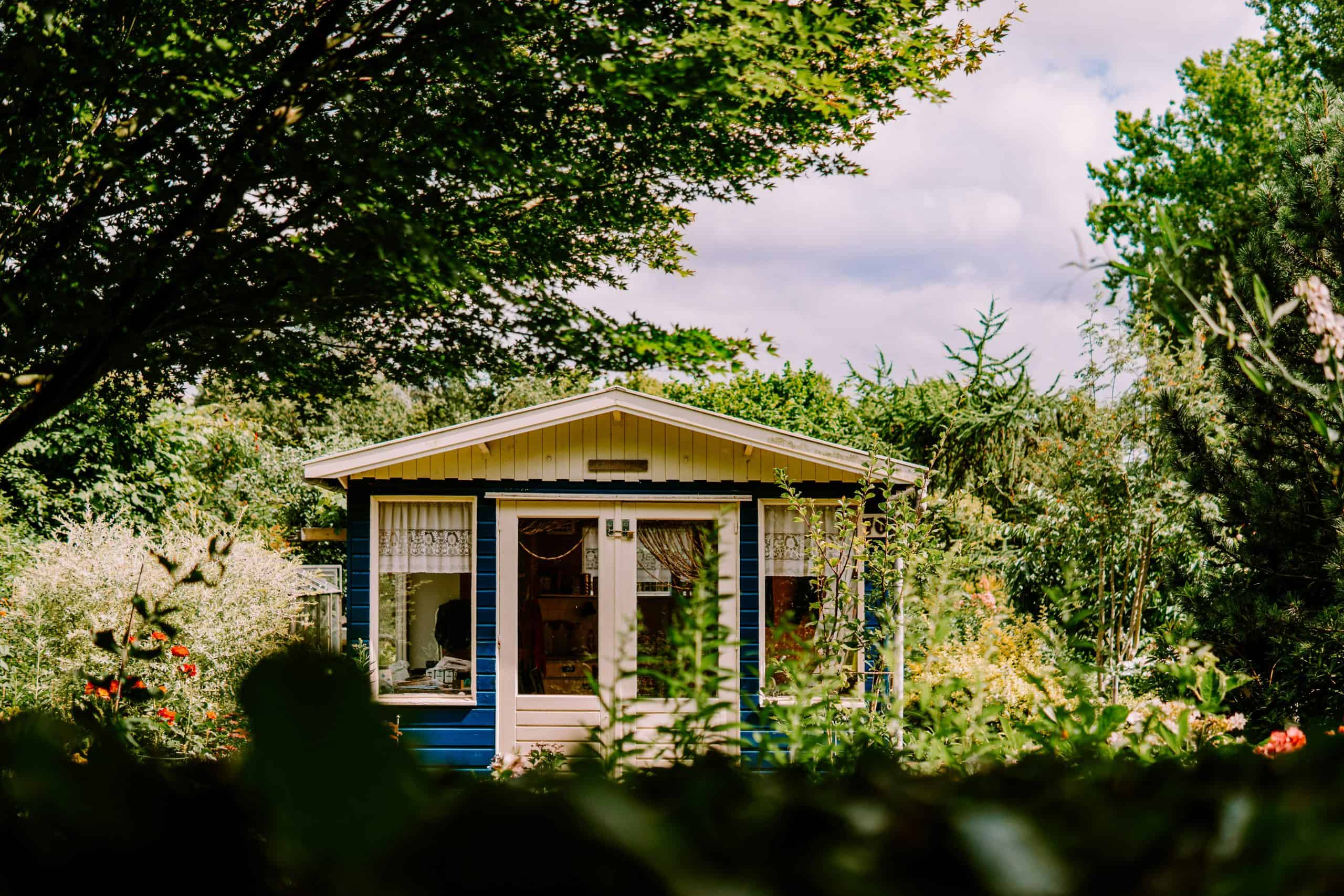 white and blue house surrounded by green trees