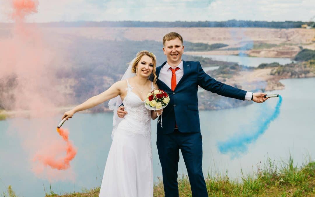 Bride and groom holding smoke bombs