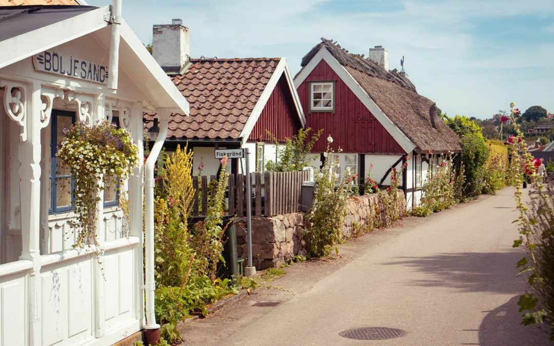 A row of houses on a street next to a fence